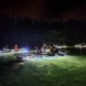 a group of people in boats in the water at night