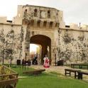 a woman walking through an entrance to a castle