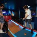 two men playing a bowling game in a bowling alley