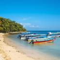 a group of boats in the water on a beach