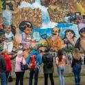 a group of people standing in front of a mural