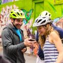 a man and woman wearing helmets looking at a cell phone