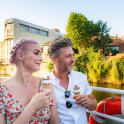 a man and a woman sitting on a boat with drinks