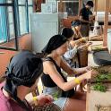 a group of women preparing food in a kitchen