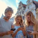 a man and two girls looking at their cell phones