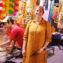 a woman standing in front of a shop in a market