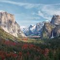 a mountain valley with trees and snow covered mountains