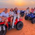 a group of women sitting on atvs in the desert