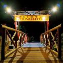 Un puente de madera por la noche con un cartel que representa un reino.