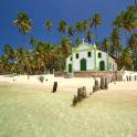 a white building on a beach with palm trees