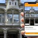 a person holding a cell phone in front of a building