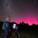a man looking at the night sky with a camera