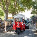 a red scooter with a canopy driving down a street