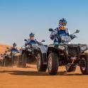a group of people riding atvs in the desert