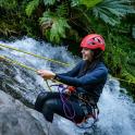 a woman in a helmet is holding onto a rope in a river