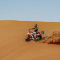一名男子在沙漠中骑着四轮摩托车