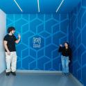 a man and a woman standing in a blue wall