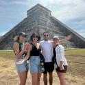 a group of people standing in front of a pyramid