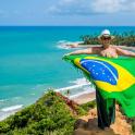 a man holding a flag on top of a beach