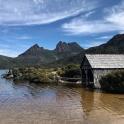 an old barn sitting in the middle of a lake