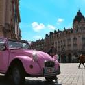 a pink car parked in front of a building