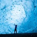 a man is standing in front of an ice cave