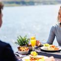 a man and a woman sitting at a table eating food