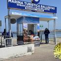 a man standing next to a kiosk on a pier
