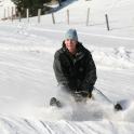 a man riding a snowboard down a snow covered slope