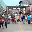 a crowd of people walking down a street in a market