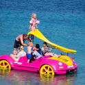 一群人骑着一辆粉色汽车在水中