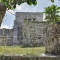 an old stone wall with a building in the background