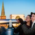a man and two women looking through a telescope
