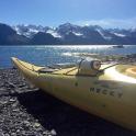 a yellow kayak sitting on the shore of a lake