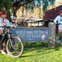 a group of people riding bikes next to a sign