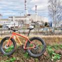 a bike parked in a field near a factory