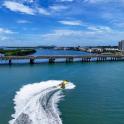 a person water skiing in the water near a bridge