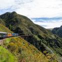 a train traveling through a mountain valley with a river