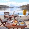 a table on the deck of a boat with food on it