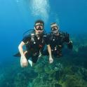 two men in scuba gear swimming in the ocean
