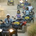 a group of people riding atvs on a dirt road