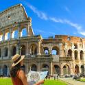 a woman in a hat standing in front of the coliseum