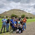 a group of people posing in front of a pyramid