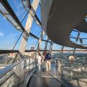 a group of people walking on a glass revolving building