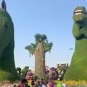a group of people standing in front of large grass figures