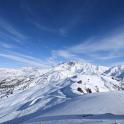 a snow covered mountain with mountains in the background
