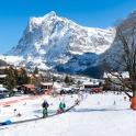 a group of people on a ski slope in front of a mountain