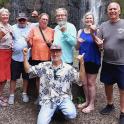 a group of people standing in front of a waterfall