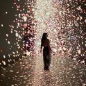a woman walking through a tunnel of lights