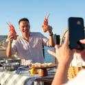 a man holding up a bunch of carrots at a table